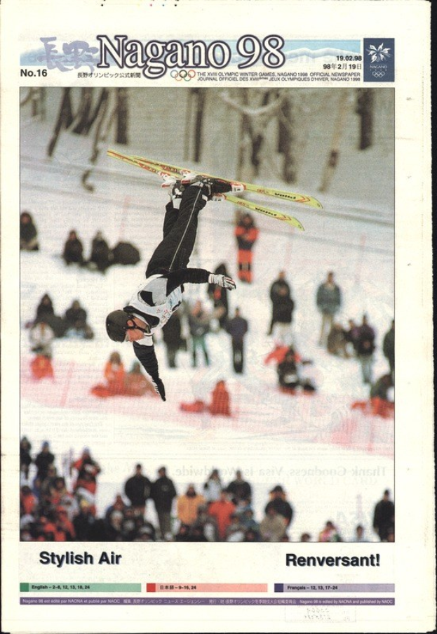 Ein Magazin-Cover mit einem Skispringer bei einem Sprung, der einen Helm, Handschuhe und Ski trägt, mit Menschen im Hintergrund und Text und Zahlen auf dem Cover.