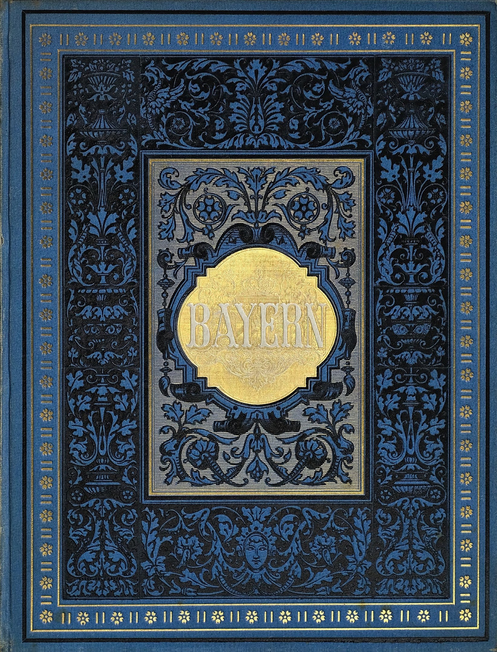 Ein blau-goldenes Buch mit dem Wort "Bayern" darauf, das mit kunstvollen Verzierungen versehen ist.