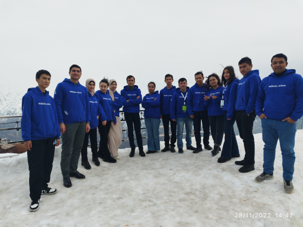 Gruppe von Menschen auf einem schneebedeckten Berg mit einem Geländer im Vordergrund, Hügel und Himmel im Hintergrund, die an einem Wintertrainingsprogramm in Nepal teilnehmen.