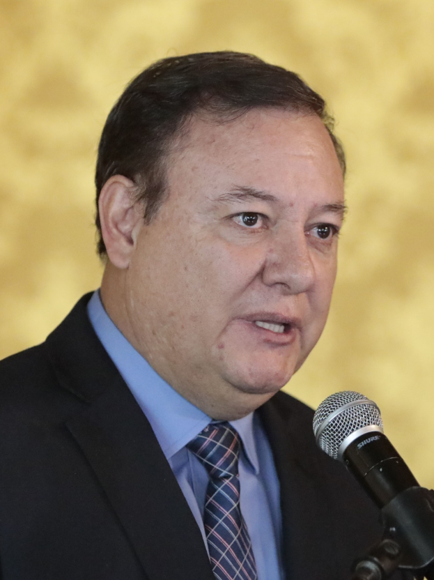 Ein Mann im Anzug spricht in ein Mikrofon und wird durch den Titel der Aufnahme als Justizminister identifiziert.