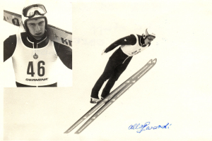 Ein Schwarz-Weiß-Foto eines Skispringers in der Luft, der einen Helm und eine Brille trägt und Ski hält, mit Text am unteren Bildrand.