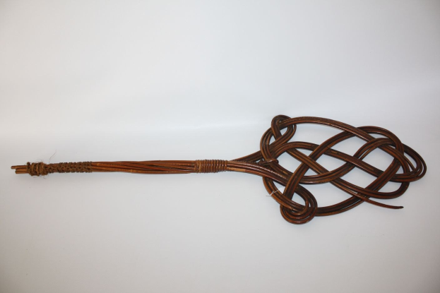 Braune Lederpeitsche mit Knoten vor einem weißen Hintergrund.