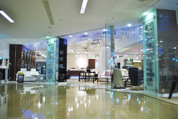 Ein hell erleuchtetes Möbelladen-Innenraum-Featuring Stühle, Sofas, Tische und andere Gegenstände, mit sichtbarem Boden und Deckenlicht und einem Friseursalon-Schild im Hintergrund.