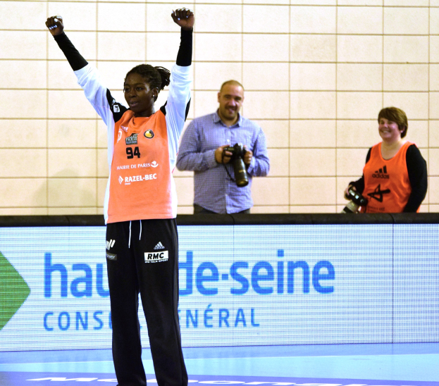 Eine Frau feiert auf einem Futsalplatz umgeben von Fotografen, im Hintergrund ein Scoreboard mit 'Futsal-Weltmeisterschaft 2015 - Frankreich gegen Belgien'
