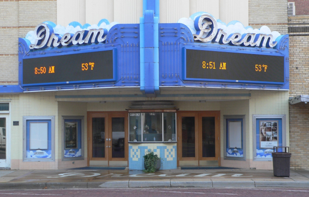 Außenansicht des Dream Theaters in St. Louis, Missouri, mit Glastüren und -fenstern, einem Namensschild, einem Mülleimer, einem Topf mit Pflanze und einer Straße unten.