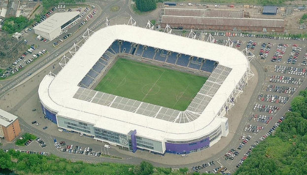 Luftaufnahme des Stadions von Tottenham Hotspur Football Club in einer Stadt, umgeben von Gebäuden, Bäumen und Straßen mit Fahrzeugen.