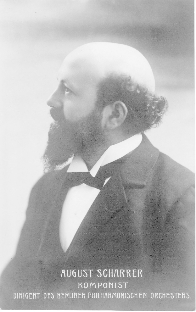 Schwarzes und weißes Foto von August Scharrer, einem deutschen Komponisten, der einen Blazer und eine Fliege trägt, mit Text am unteren Bildrand.