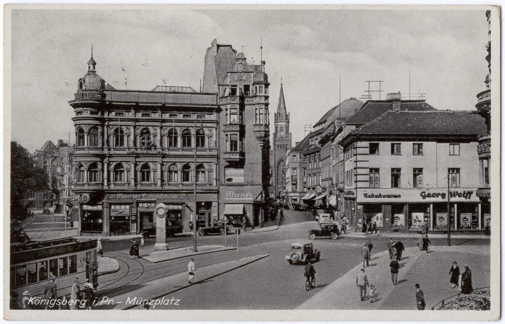 Schwarz-weiß-Foto einer belebten Münchner Stadtstraße mit Fußgängern, Fahrzeugen und Gebäuden, Bäumen im Hintergrund und Text unten.