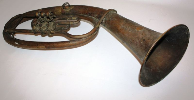 Alter Messinghorn mit glänzendem Finish, gebogener Hals und aufgeblähter Schalltrichter, verziert mit detaillierten Gravuren auf einem weißen Hintergrund.