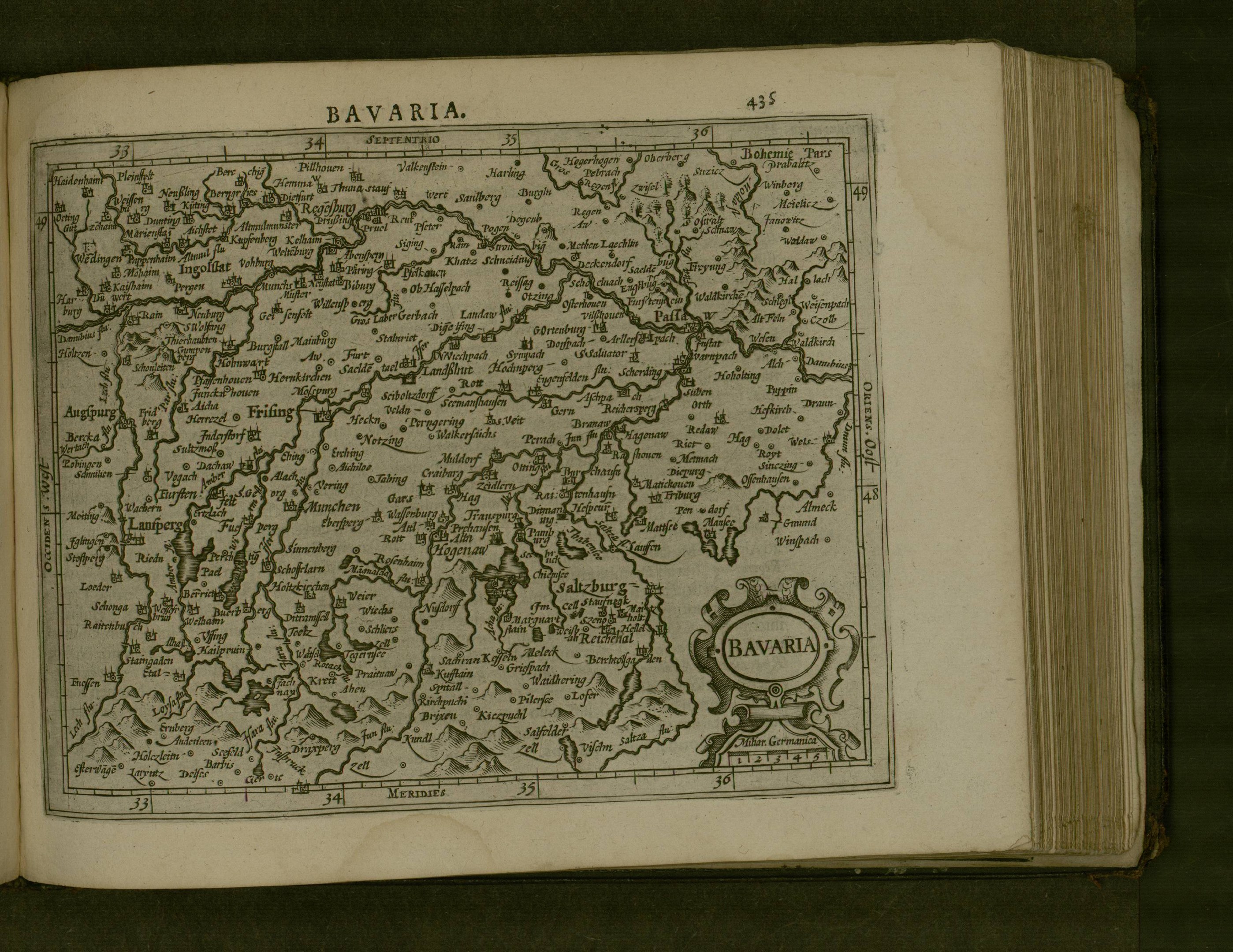 Offenes Buch mit detaillierter Karte von Bayern mit beschrifteten Städten und Ortschaften, begleitet von beschreibendem Text.