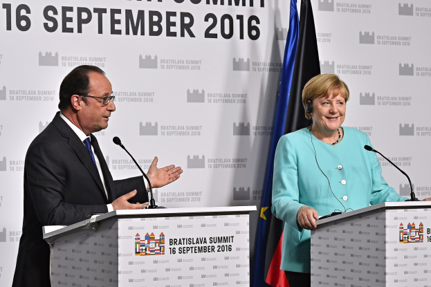 Bundeskanzlerin Angela Merkel und Frankreichs Präsident François Hollande, die auf einem Podium mit der Aufschrift "Bratislava-Gipfel 2016" lächeln.