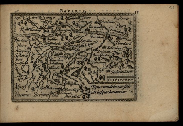 Ein detailliertes altes Buch mit einer Karte von Bayern, auf der Städte und Ortschaften markiert sind, vor einem schwarzen Hintergrund.