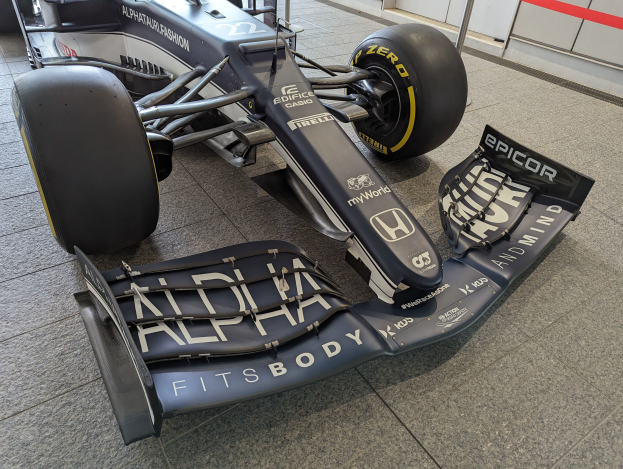 Ein schwarz-weißer McLaren MP4-31 Formel-1-Rennwagen im McLaren Museum ausgestellt, mit einem großen Heckflügel und aerodynamischem Design.