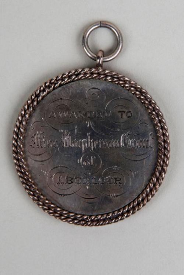 Silberne Rundmedaille mit schwarzer Aufschrift "Ausgezeichnet für den Stadtrat" an einem Band, verziert mit einem dekorativen Rand.