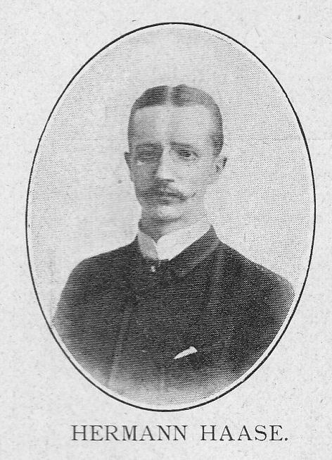 Schwarz-weißes Portr├Ąt von Hermann Haase, einem deutschen Komponisten und Pianisten, der einen Anzug tr├Ągt und einen Schnurrbart hat, mit ernstem Gesichtsausdruck, und deutscher Text unten.