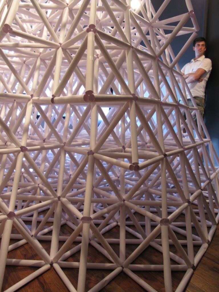 Ein hoher Holzturm mit einer Person dahinter und einem Holzboden an der Basis.