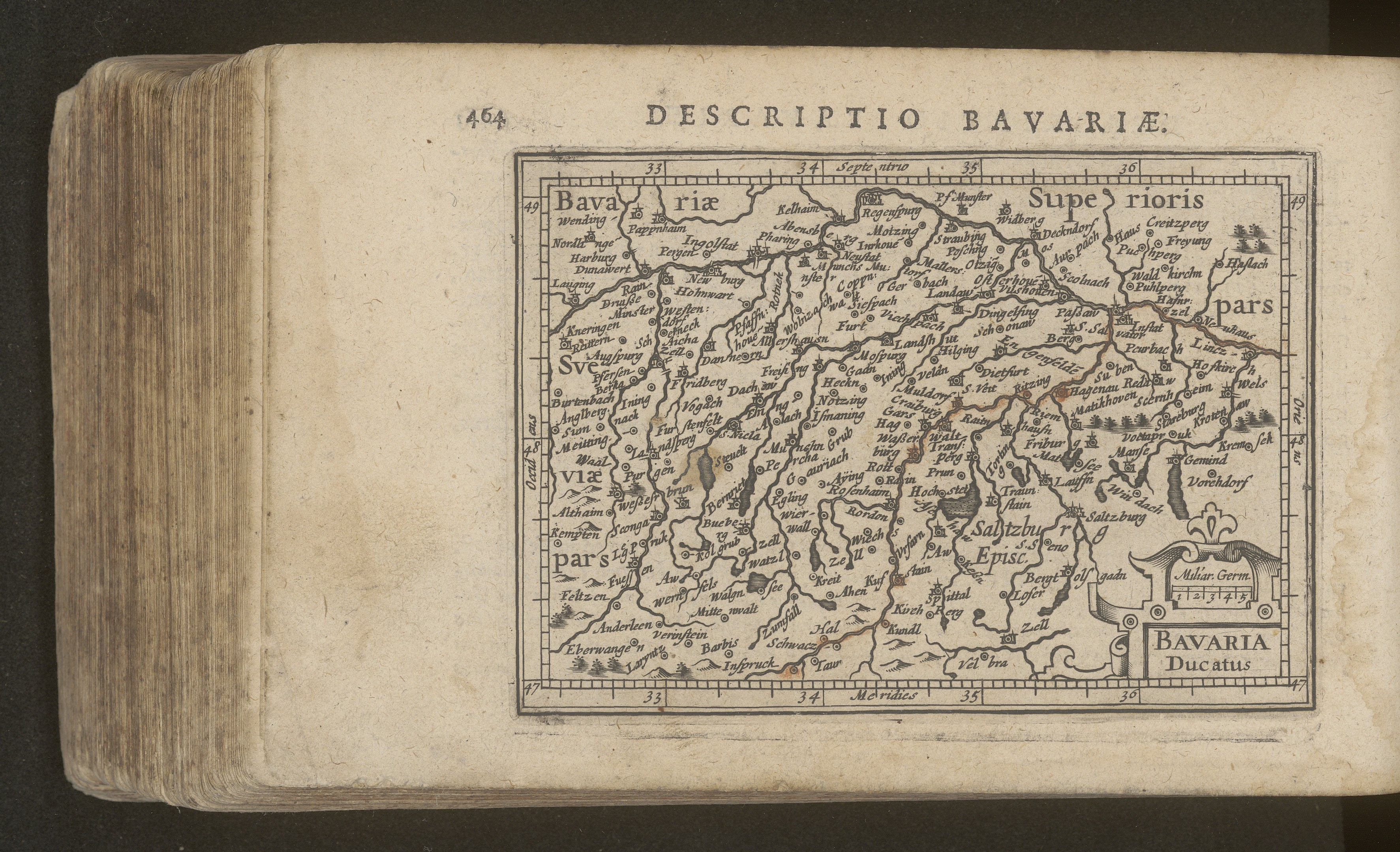 Eine detaillierte Karte von Bayern auf dem Cover eines alten Buches vor schwarzem Hintergrund.