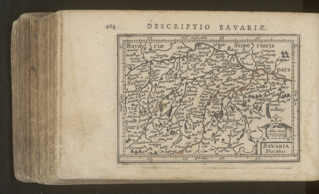 Eine detaillierte Karte von Bayern auf dem Cover eines alten Buches vor schwarzem Hintergrund.