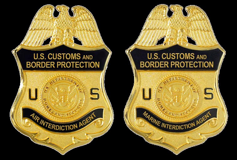 Zwei goldfarbene Abzeichen mit 'U.S. Customs and Border Protection'-Text vor einem weißen Hintergrund.