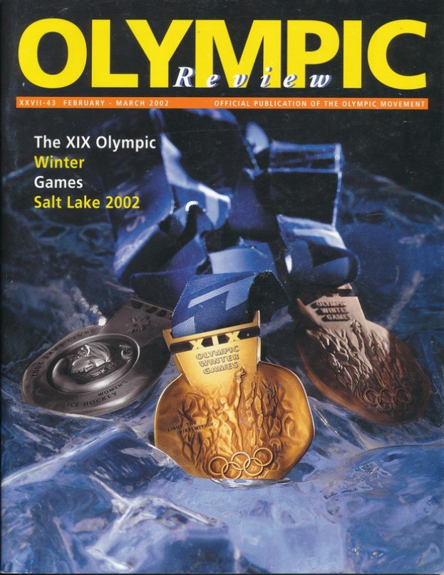 Buch mit dem Titel "Olympische Revue" mit mehreren Medaillen in verschiedenen Größen und Farben und fetter Schrift auf dem Cover.